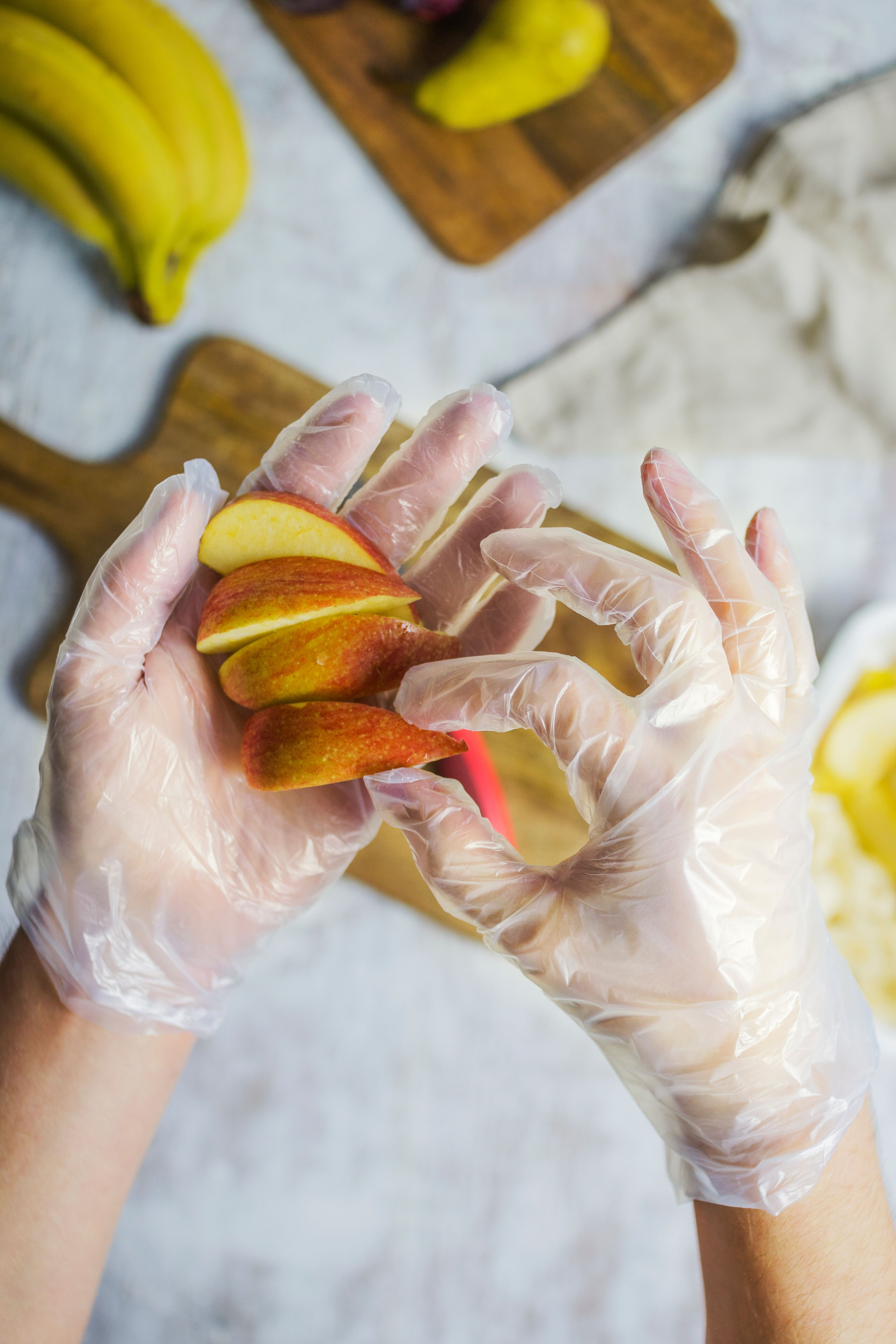Vegware's compostale food handler gloved hands holding aplle slices