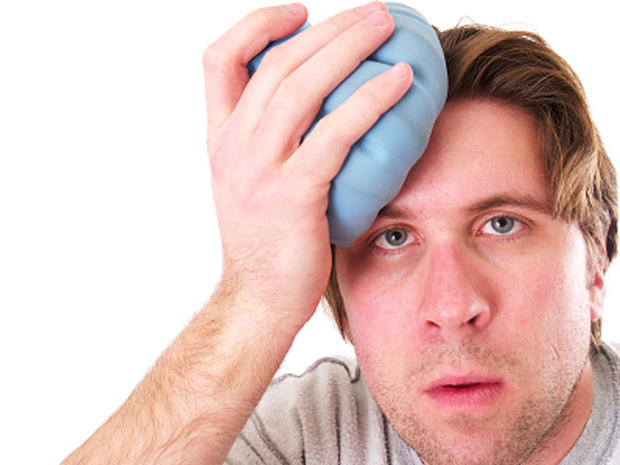 male holding an icepack on his forehead