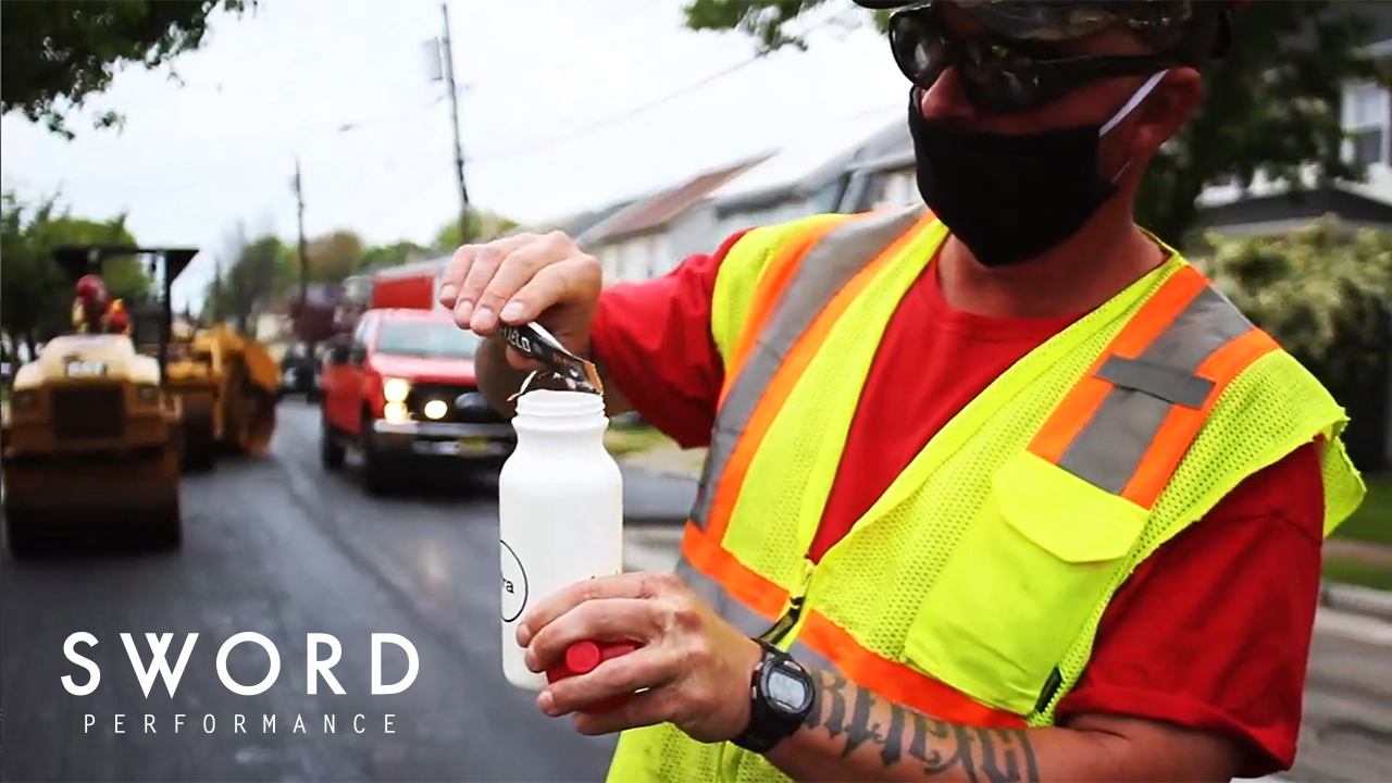 Construction worker preparing a SWORD electolyte drink