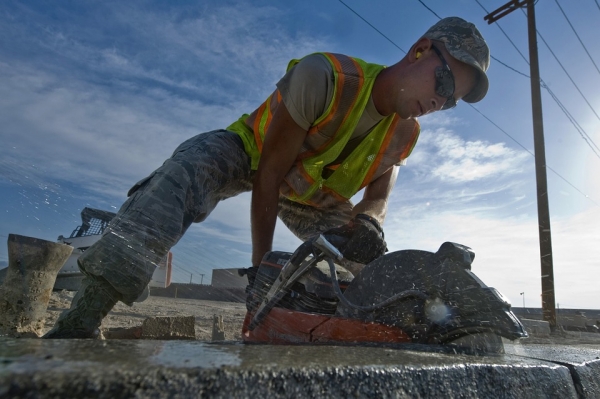 Worker in hi-viz vest cutting concrete